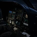 Cockpit view of a helicopter during night flight operation, showing instrument panels and controls with landscape below, illustrating helicopter operational safety and night-flight readiness